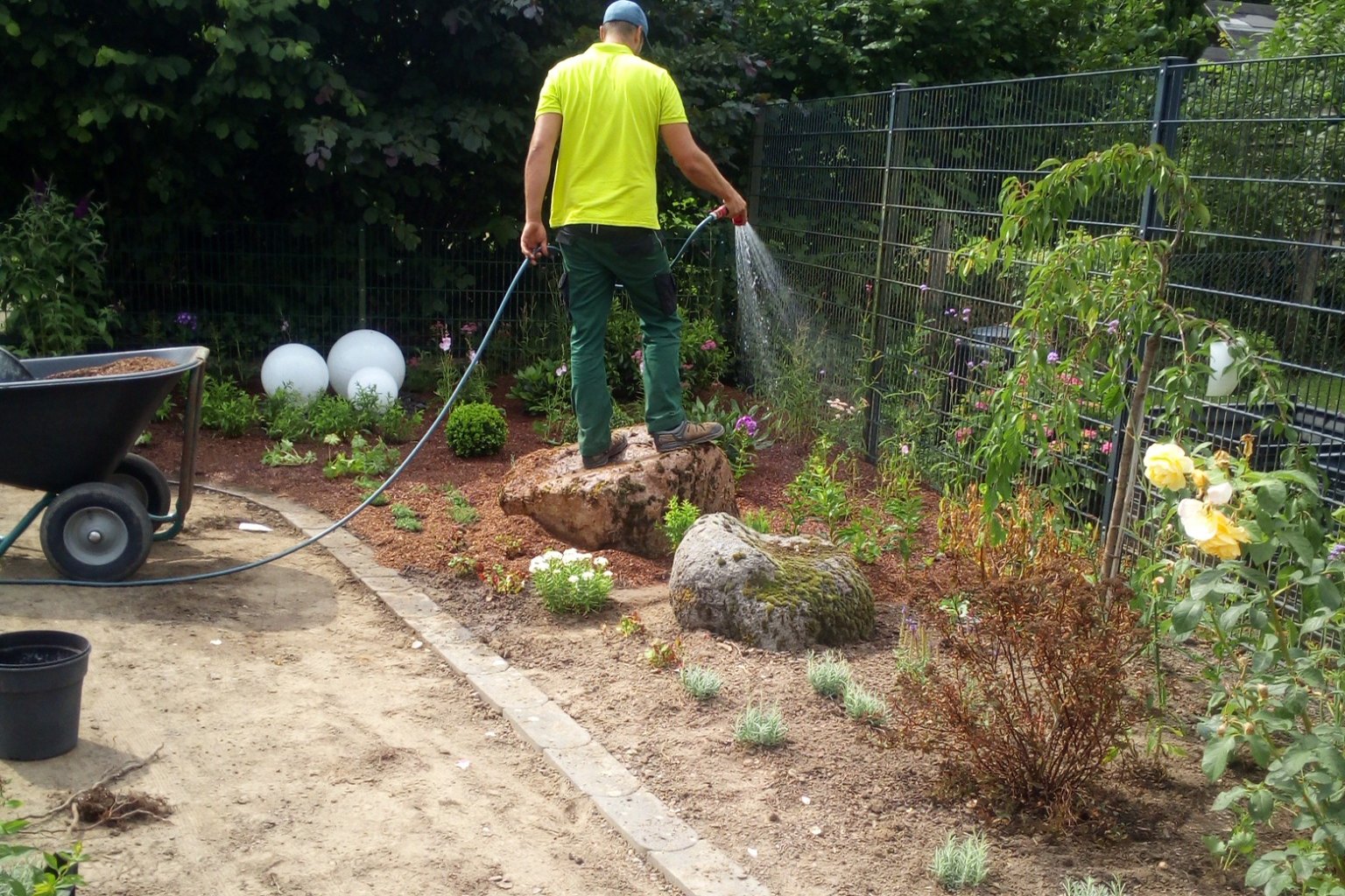 Mitarbeiter der SH Gartenservice GbR bei der Pflege einer Gartenbepflanzung