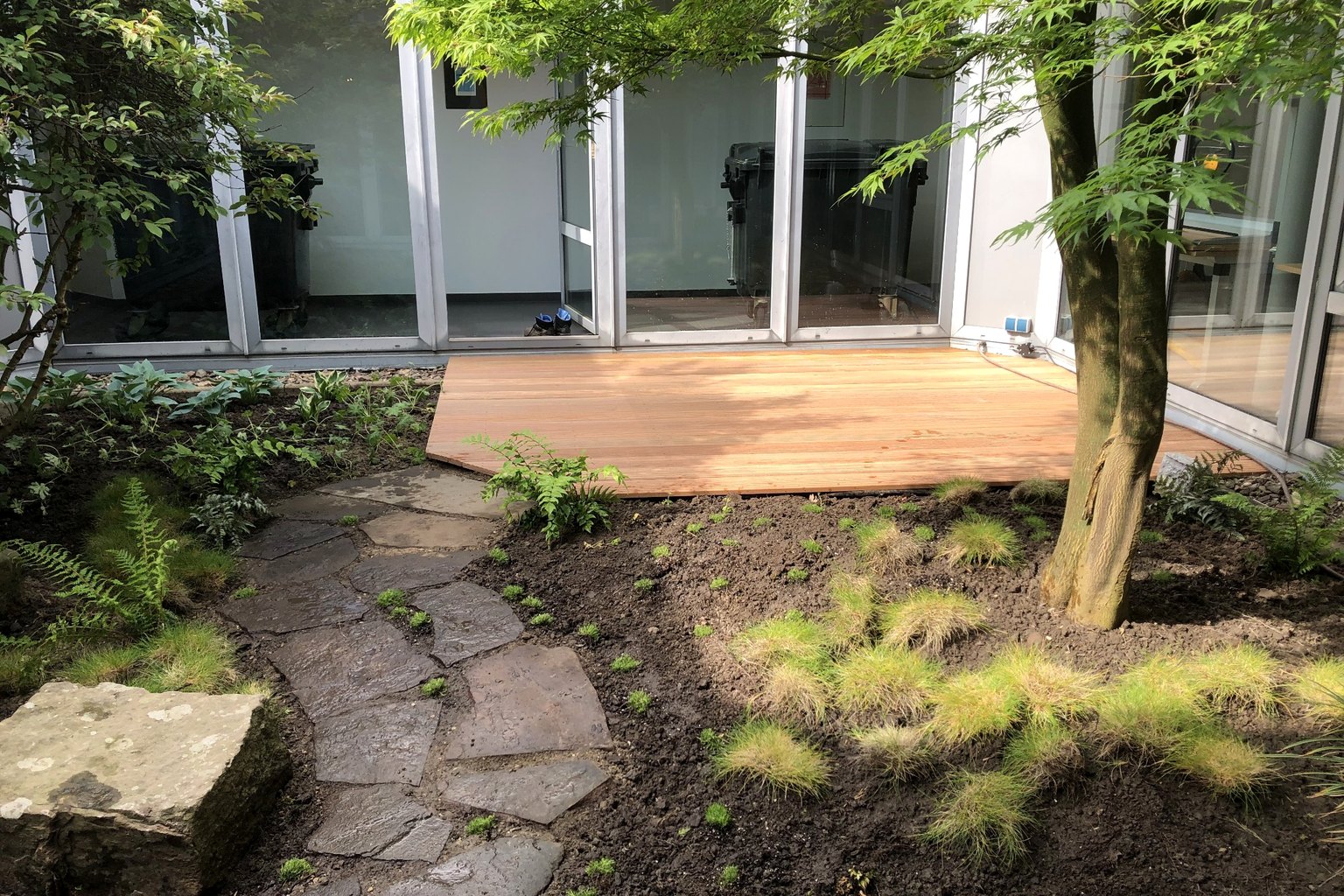 Neu gestalteter Gartenbereich mit Terrasse, Natursteinweg und Pflanzflächen