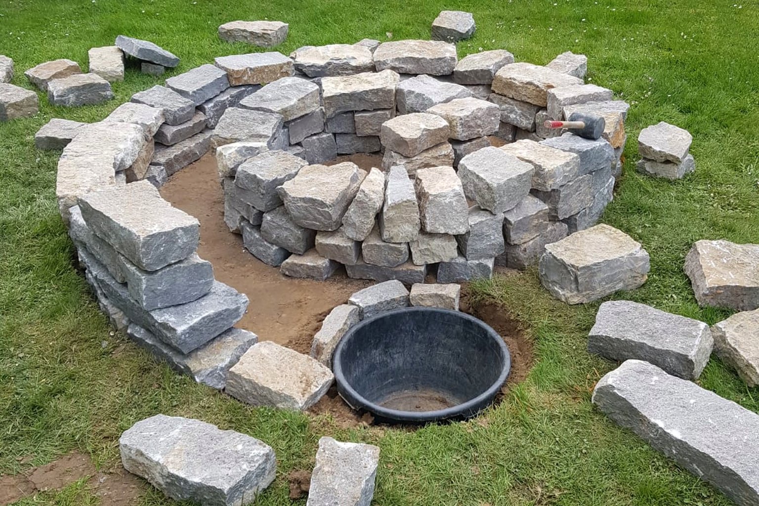 Natursteinarbeiten während der Gestaltung eines Gartenbereichs